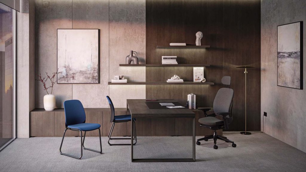 Taula d'oficina de direcció amb estructura metàl·lica, cadira ergonòmica grisa i cadires de visita blaves